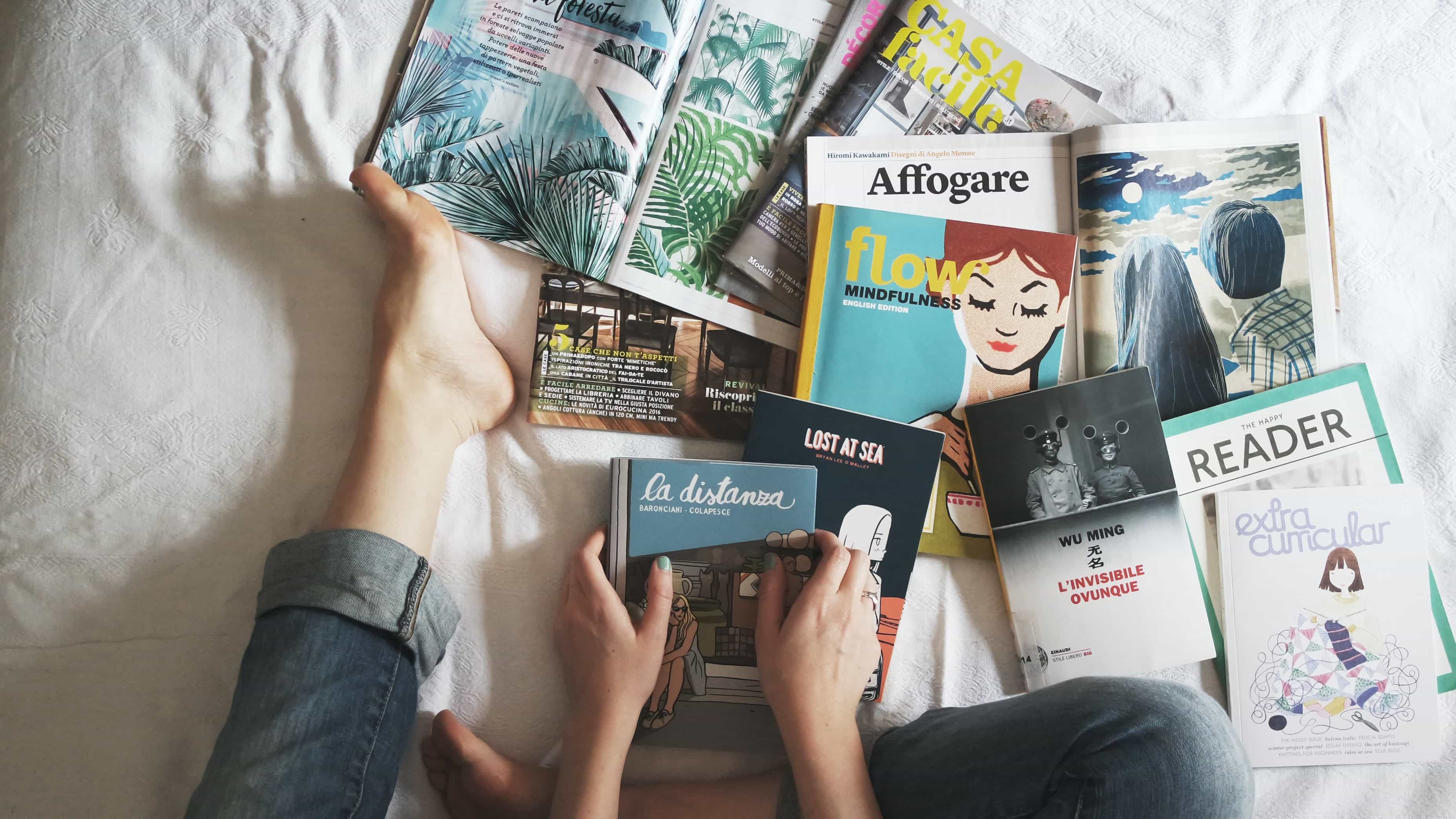 Books and magazines laying open on a bed